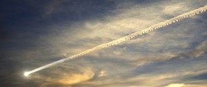 Photo of meteor streaking across evening sky, wispy clouds