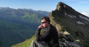 Photo of Tom looking pensive on a mountainside