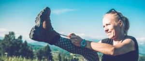 Hiker tying her shoe in the mountains, outdoor photography.