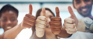 Photo of diverse team all giving thumbs up
